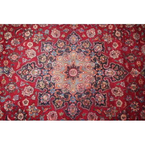 829 - A LARGE EASTERN WOOLLEN RUG IN MAINLY RED AND BLACK PATTERN 377 x 275 cm