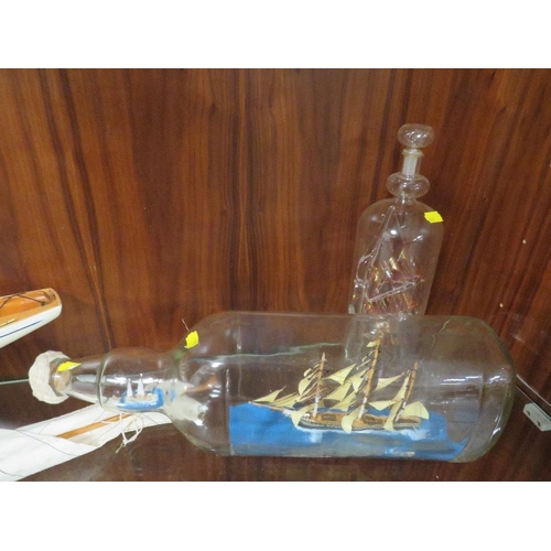 207 - A VINTAGE MODEL OF A YACHT ON STAND TOGETHER WITH TWO SHIPS IN A BOTTLE