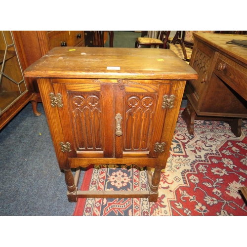 707 - A SMALL OAK GOTHIC TWO DOOR BEDSIDE CUPBOARD