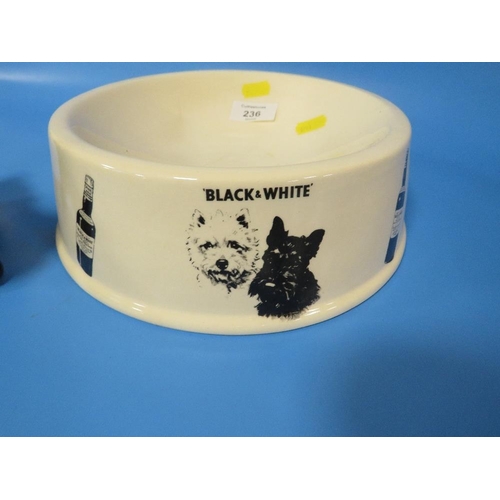 236 - A BLACK AND WHITE WHISKY DOG BOWL TOGETHER WITH A MODEL OF A BLACK SCOTTIE DOG