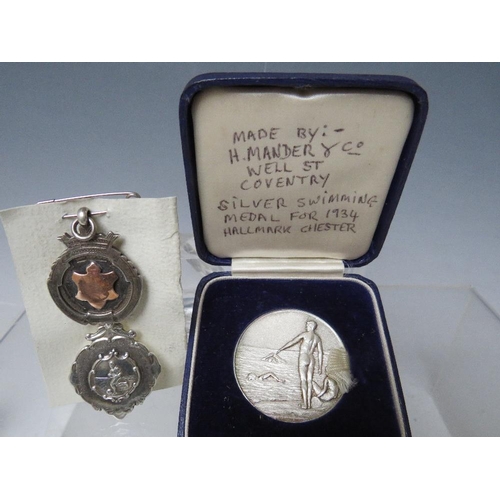 134 - A CASED SILVER SWIMMING MEDAL - CHESTER 1934, together with two hallmarked silver fobs (3)