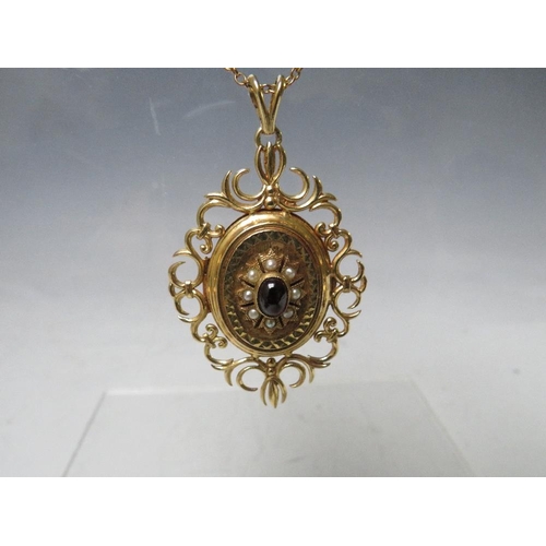 145 - A HALLMARKED 9CT GOLD LOCKET, with fancy openwork border, set with a central cabochon garnet, with a... 