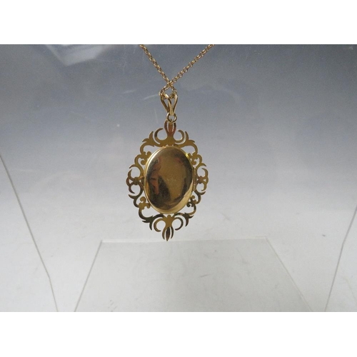 145 - A HALLMARKED 9CT GOLD LOCKET, with fancy openwork border, set with a central cabochon garnet, with a... 