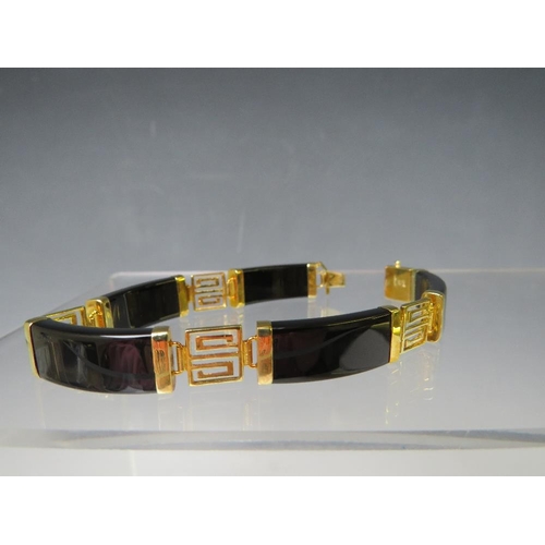 147 - AN ORIENTAL YELLOW METAL AND ONYX PANEL LINK BRACELET, marked to clasp 14K, HKong with hallmarks