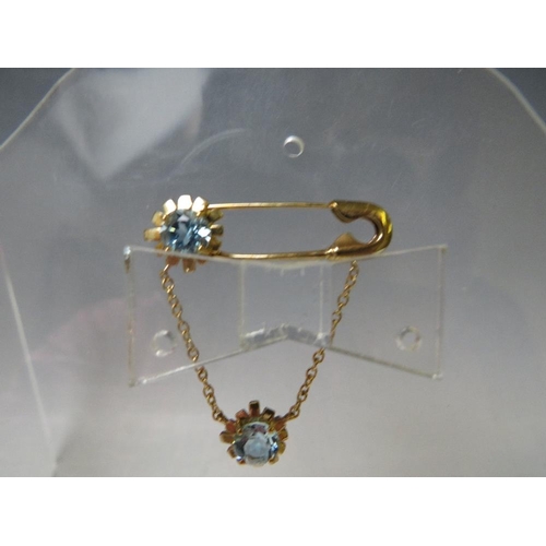 148 - A HALLMARKED 9CT GOLD UNUSUAL GEMSET BROOCH, in the form of a safety pin with two floral adornments ... 