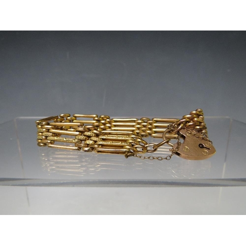 149 - A YELLOW METAL FOUR BAR GATE BRACELET, with heart shaped clasp and safety chain stamped 9ct, having ... 