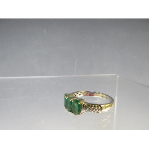 157 - AN 18CT WHITE GOLD 'ILIANA' THREE STONE EMERALD RING, with diamond chip set shoulders, ring size O t... 