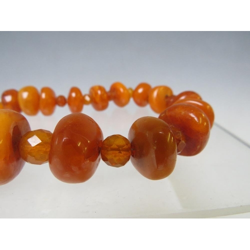 164 - AN UNUSUAL VINTAGE AMBER BEAD NECKLACE, the chunky disc shaped amber bead interspersed with small fa... 