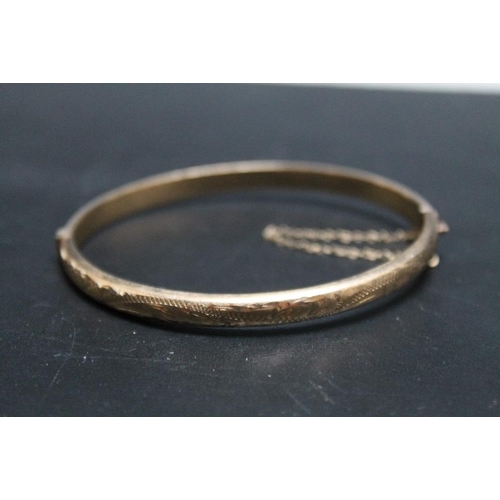 168 - A HALLMARKED 9 CARAT GOLD HINGED BANGLE, with typical ornate engraving to front section, approx weig... 