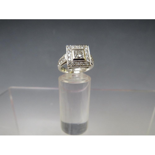 170 - A HALLMARKED HANDMADE 18 CARAT WHITE GOLD DIAMOND RING, set with a central Princess cut diamond of a... 