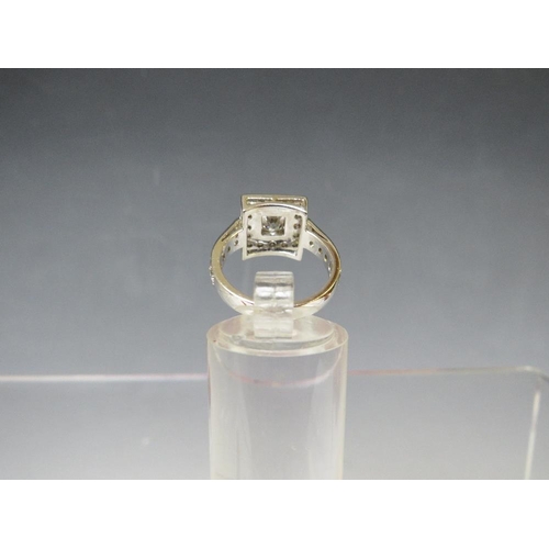 170 - A HALLMARKED HANDMADE 18 CARAT WHITE GOLD DIAMOND RING, set with a central Princess cut diamond of a... 