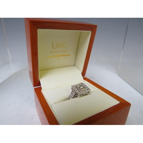 170 - A HALLMARKED HANDMADE 18 CARAT WHITE GOLD DIAMOND RING, set with a central Princess cut diamond of a... 