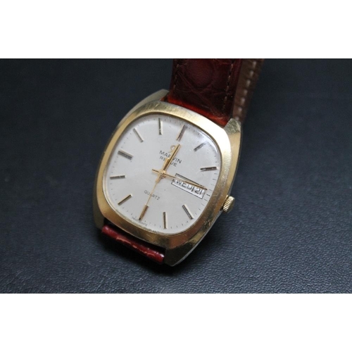 188 - A HALLMARKED 9 CARAT GOLD MARVIN REVUE DAY DATE QUARTZ WRIST WATCH, on leather strap with plated fas... 