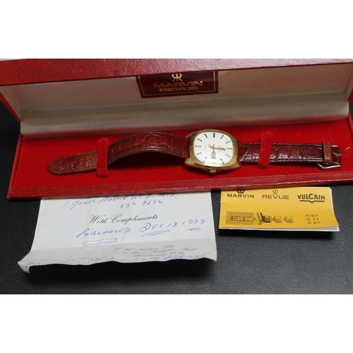 188 - A HALLMARKED 9 CARAT GOLD MARVIN REVUE DAY DATE QUARTZ WRIST WATCH, on leather strap with plated fas... 