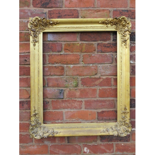 25 - A GILT RECTANGULAR PICTURE FRAME, with foliate moulded detail to each corner, rebate 68 x 55 cm