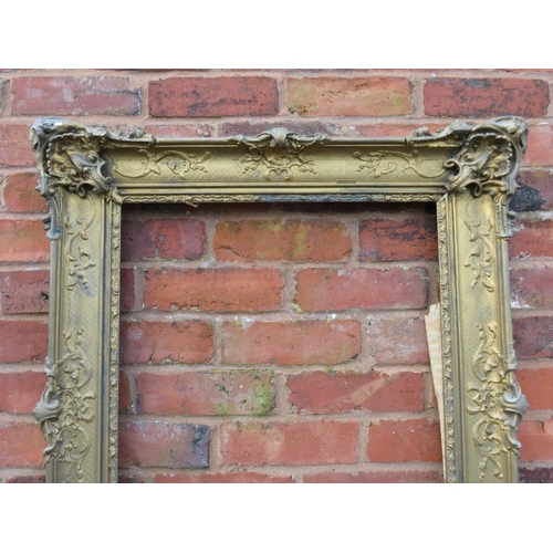 26 - A GILT RECTANGULAR PICTURE FRAME, with raised moulded foliate detail, rebate 65 x 52 cm