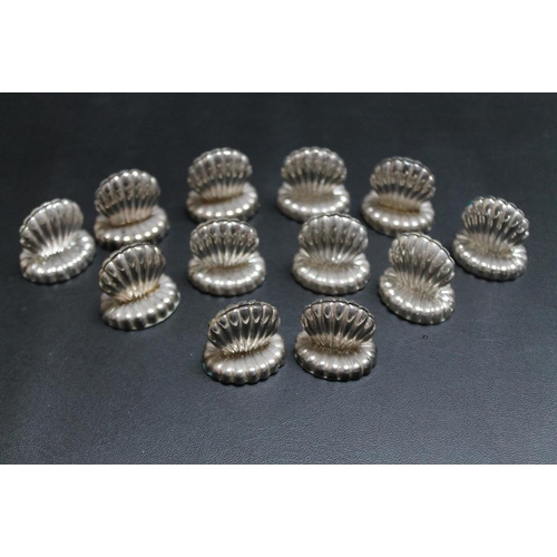 262 - A NOVELTY SET OF TWELVE SILVER PLATED MENU HOLDERS IN THE FORM OF CLAM SHELLS, H 3 cm