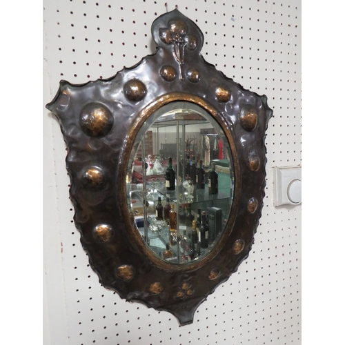 270 - AN USUAL EARLY 20TH CENTURY COPPER SHIELD SHAPED WALL MIRROR, with stylised floral detail to the top... 