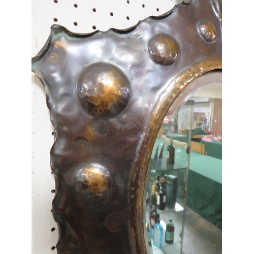 270 - AN USUAL EARLY 20TH CENTURY COPPER SHIELD SHAPED WALL MIRROR, with stylised floral detail to the top... 