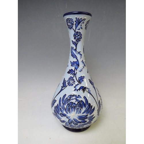 345 - A MOORCROFT POTTERY FLORIAN ONION VASE, with tubelined floral sprays on a contrasting blue ground, m... 