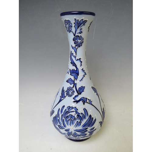 345 - A MOORCROFT POTTERY FLORIAN ONION VASE, with tubelined floral sprays on a contrasting blue ground, m... 