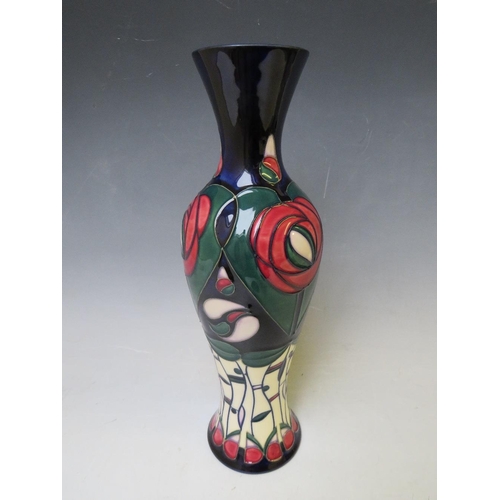 348 - A MOORCROFT POTTERY BALUSTER VASE, with tubelined floral design on a dark blue ground, marks and sig... 