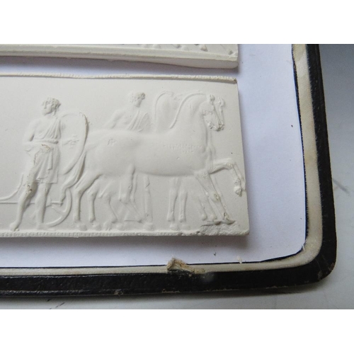 381 - THREE GRAND TOUR STYLE PLAQUES, depicting classical friezes of horsemen, in leather bound case, each... 