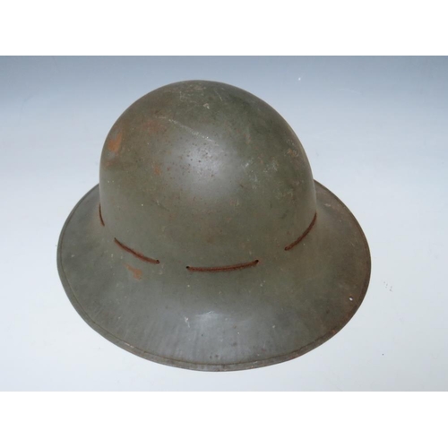 429 - A BRITISH TIN HELMET DATED 1941, with stencilled S.F.P. to the front together with an Eastern Europe... 