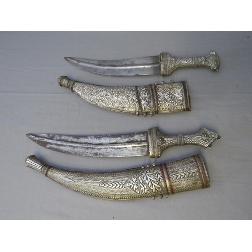 432 - FOUR MIDDLE EASTERN JAMBIYA DAGGERS, all with typical curved blades and sheet white metal decoration