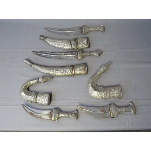 432 - FOUR MIDDLE EASTERN JAMBIYA DAGGERS, all with typical curved blades and sheet white metal decoration