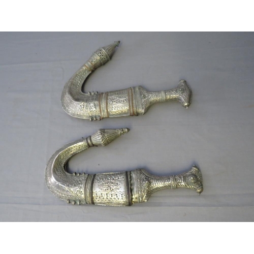 432 - FOUR MIDDLE EASTERN JAMBIYA DAGGERS, all with typical curved blades and sheet white metal decoration