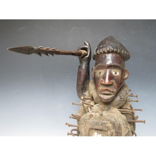 434 - A KONGO POWER FIGURE BRANDISHING AN IRON SPEAR WITH INSET GLASS EYES AND A PANEL TO HIS ABDOMEN, H 4... 