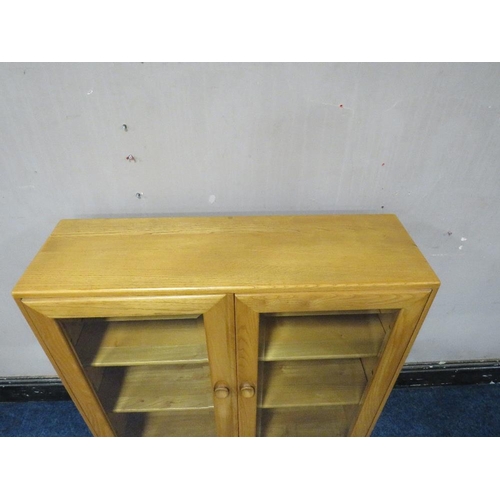 494 - AN ERCOL LIGHT ELM GLAZED TWO DOOR BOOKCASE, H 98 cm, W 91 cm