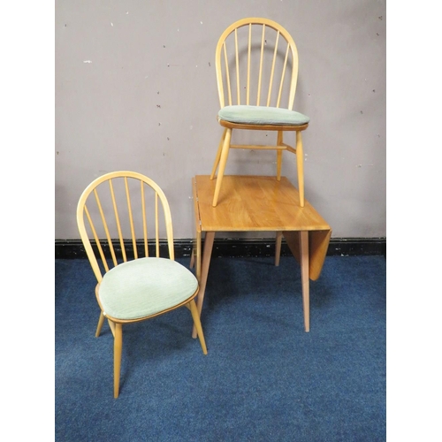 495 - AN ERCOL LIGHT ELM DROPLEAF TABLE, together with two hoop back chairs