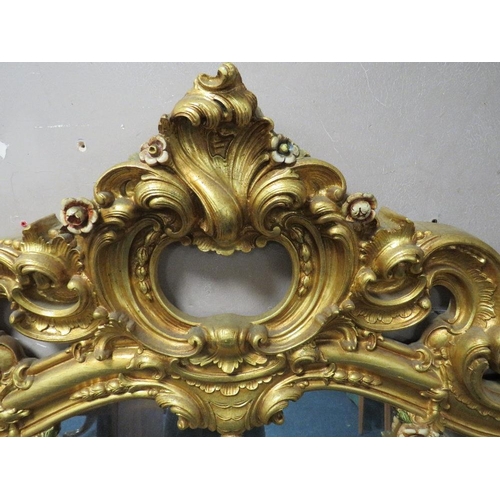 497 - A LARGE MODERN GILT COMPOSITE OVERMANTLE MIRROR, with Rococo and floral scrolling, 172 x 170 cm