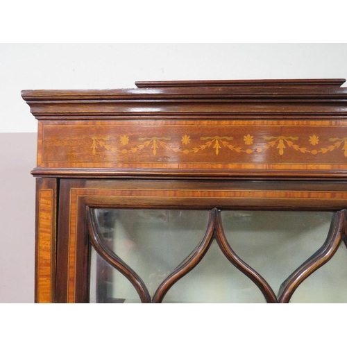 499 - AN EDWARDIAN MAHOGANY INLAID DISPLAY CABINET, the serpentine fronted lower section with single door,... 