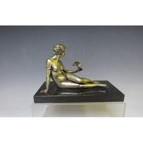 281 - A 20TH CENTURY ART DECO STUDY OF A SILVERED METAL FEMALE NUDE HOLDING A BIRD, raised on a slate base... 