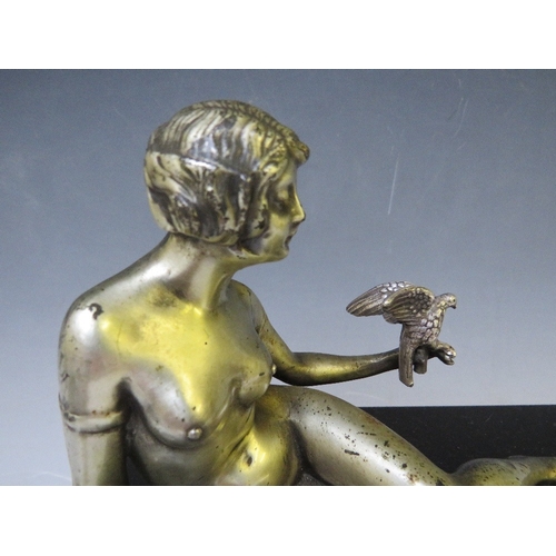 281 - A 20TH CENTURY ART DECO STUDY OF A SILVERED METAL FEMALE NUDE HOLDING A BIRD, raised on a slate base... 