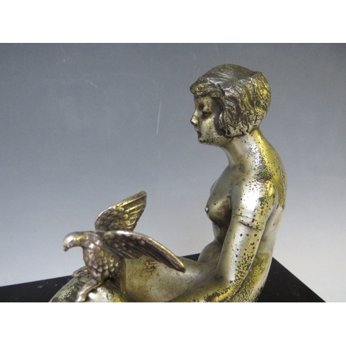 281 - A 20TH CENTURY ART DECO STUDY OF A SILVERED METAL FEMALE NUDE HOLDING A BIRD, raised on a slate base... 