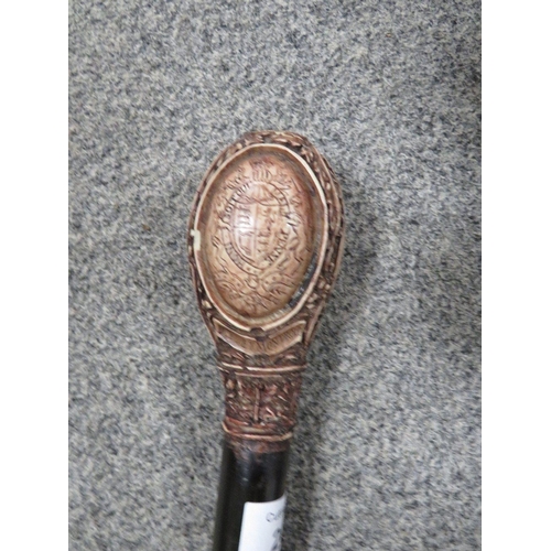 201 - A REPRODUCTION WALKING CANE WITH A CARVED HANDLE