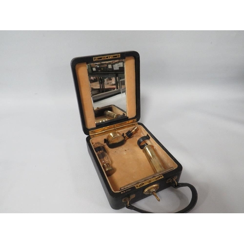 298 - A SMALL TRAVELLING VANITY CASE WITH HALLMARKED SILVER GILT ACCESSORIES,  complete with a base metal ... 