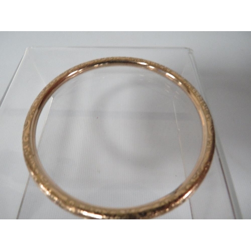 364 - AN ANTIQUE ENGRAVED BANGLE MARKED ROLLED GOLD