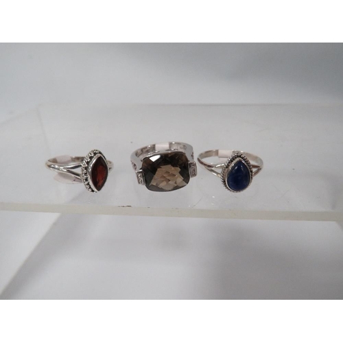 394 - THREE DECORATIVE SILVER DRESS RINGS TO INCLUDE A SMOKY QUARTZ STYLE EXAMPLE