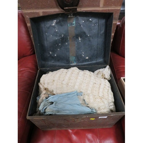 115 - A TIN TRUNK CONTAINING A VINTAGE WEDDING DRESS TOGETHER WITH OTHER VINTAGE CLOTHING