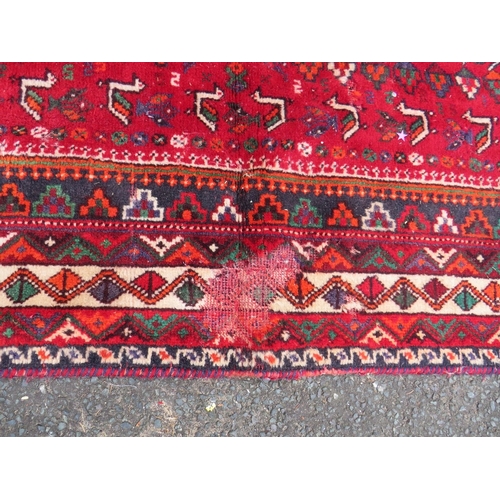 764 - A LARGE EASTERN RED/BLACK WOOLLEN RUG - APPROX 300 x 213 cm