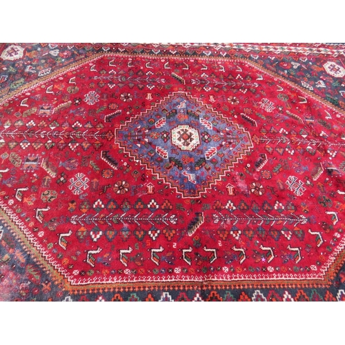 764 - A LARGE EASTERN RED/BLACK WOOLLEN RUG - APPROX 300 x 213 cm