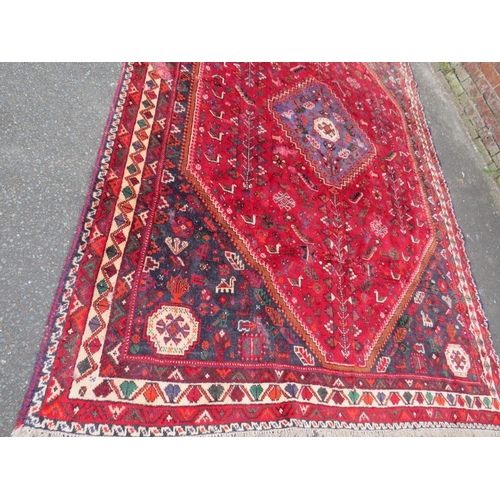 764 - A LARGE EASTERN RED/BLACK WOOLLEN RUG - APPROX 300 x 213 cm