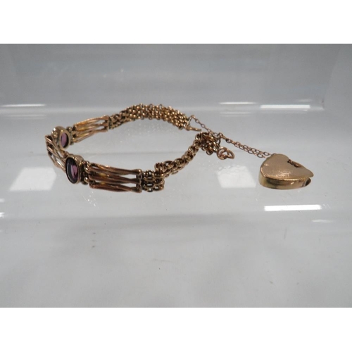 400 - A VICTORIAN ROLLED GOLD BRACELET SET WITH AMETHYST COLOURED STONES