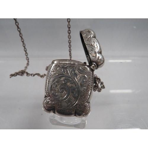 423 - AN ANTIQUE SILVER VESTA CASE ON SILVER CHAIN