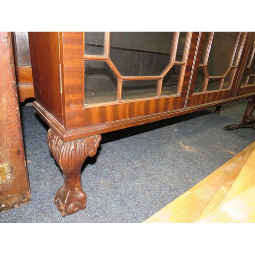 756 - A 20TH CENTURY MAHOGANY GLAZED THREE DOOR BOOKCASE ON BALL AND CLAW FEET 126 X 145 CM